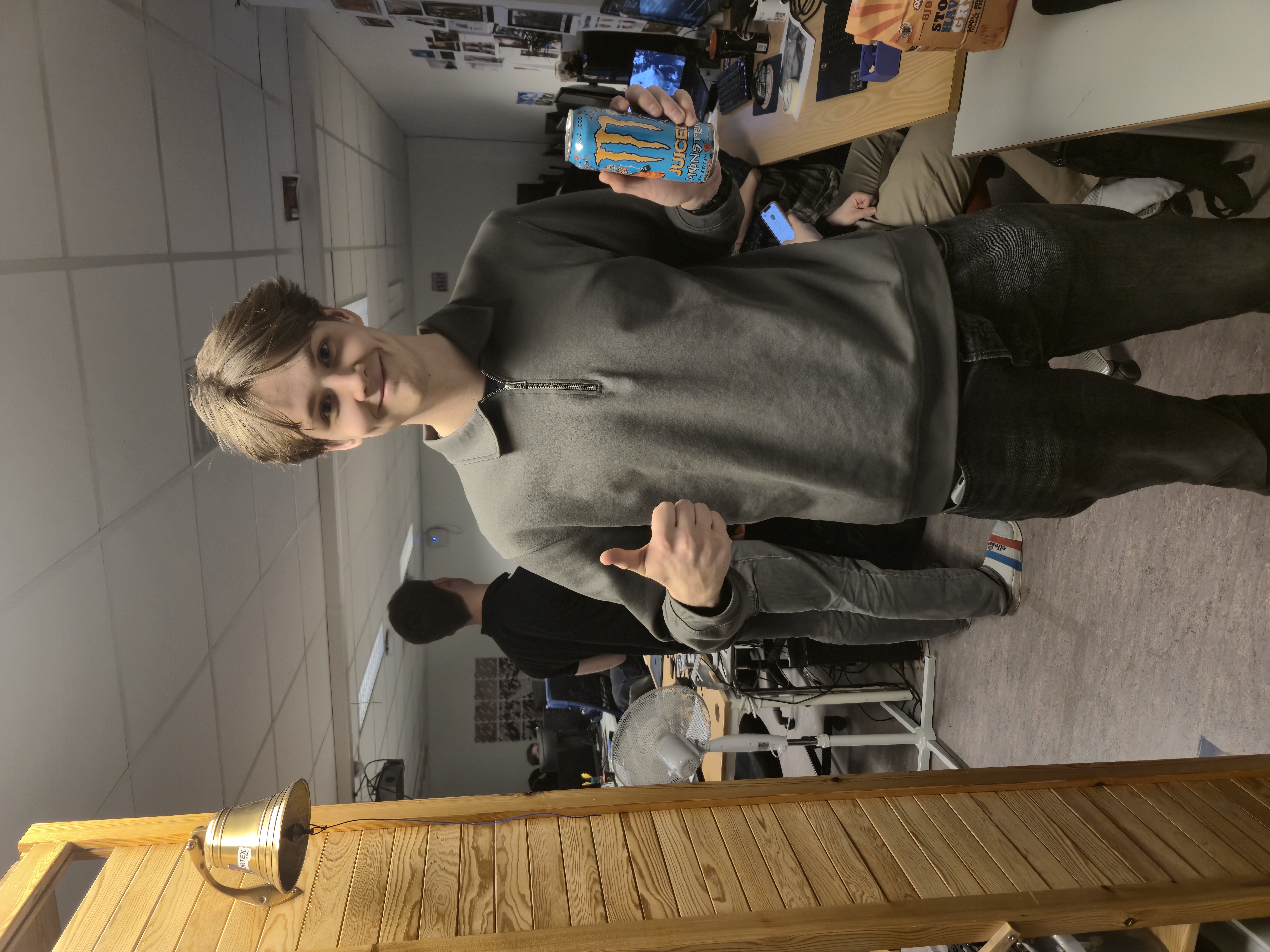 A team member giving a thumbs up holding a Monster energy drink.