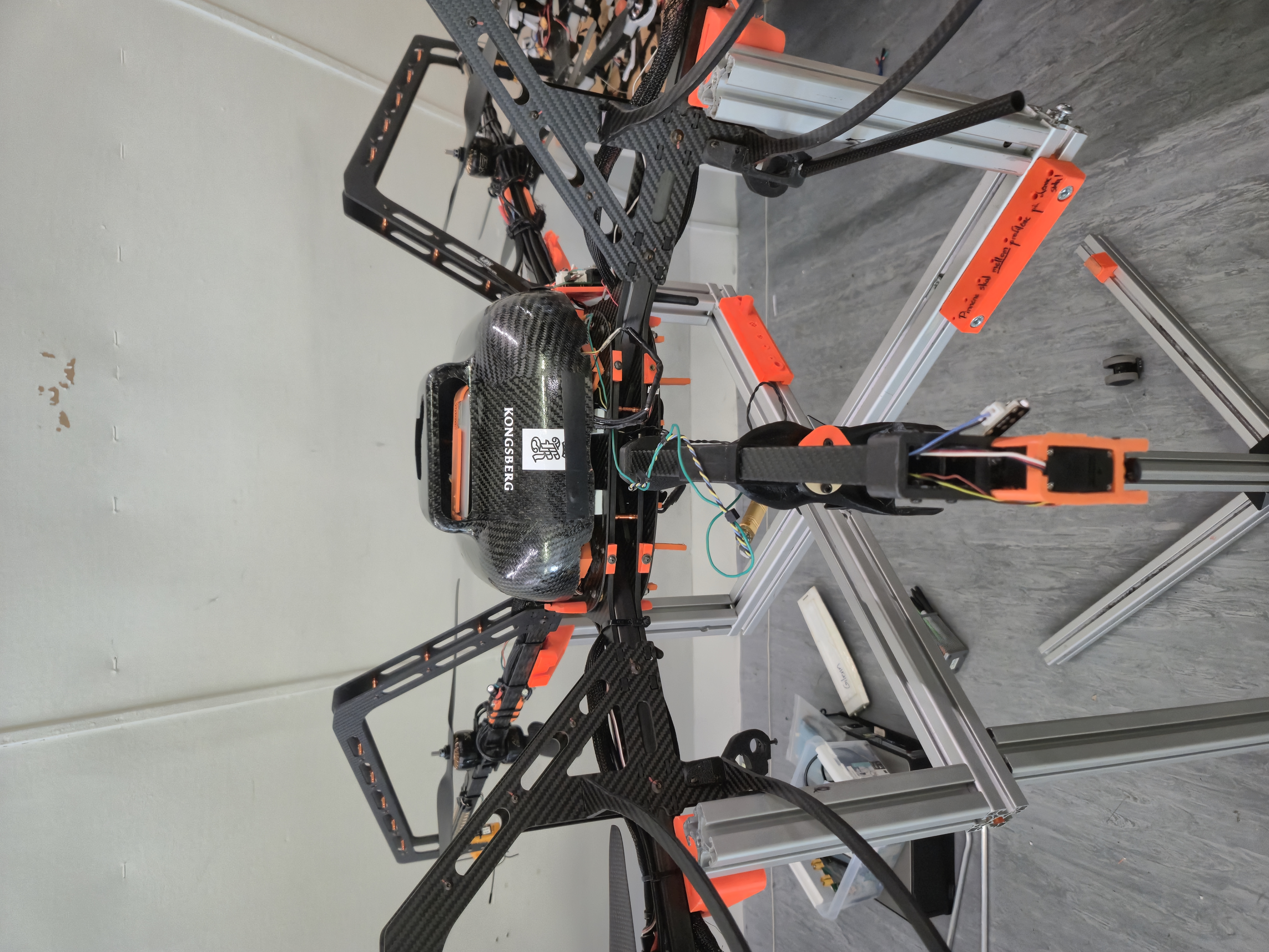 Close-up of Ascend NTNU's autonomous drone showing the carbon fiber frame, electronics, and orange 3D-printed parts.